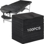 Stack of 100 black FELISTORY disposable non-woven massage table sheets, folded neatly.