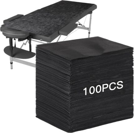 Stack of 100 black FELISTORY disposable non-woven massage table sheets, folded neatly.