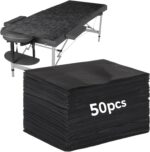 Stack of 100 black FELISTORY disposable non-woven massage table sheets, folded neatly.