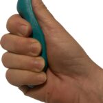 A green, thumb-shaped plastic massage tool designed for deep tissue and trigger point therapy, held in a hand.