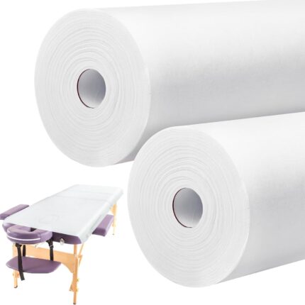 Two rolls of white disposable non-woven massage table sheets, neatly stacked and ready for use in a professional setting.