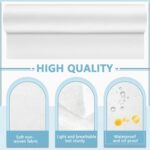 Two rolls of white disposable non-woven massage table sheets, neatly stacked and ready for use in a professional setting.