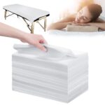 Stack of 100 white disposable bed sheets for massage and spa tables, neatly folded.