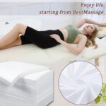 Stack of 100 white disposable bed sheets for massage and spa tables, neatly folded.