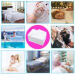 Stack of 100 white disposable bed sheets for massage and spa tables, neatly folded.